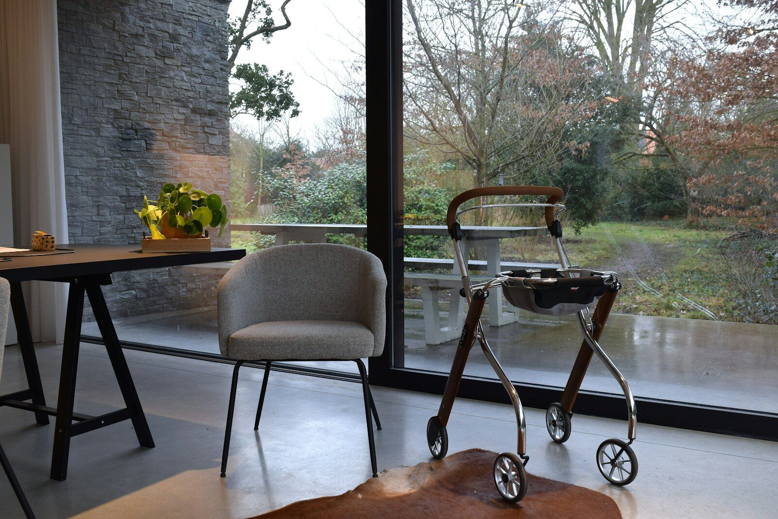 A walker and chair by a large window