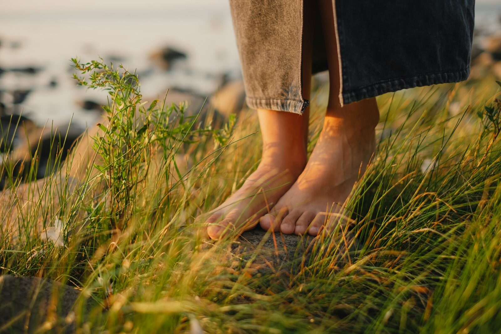 A person standing on a hill with their feet in the grass